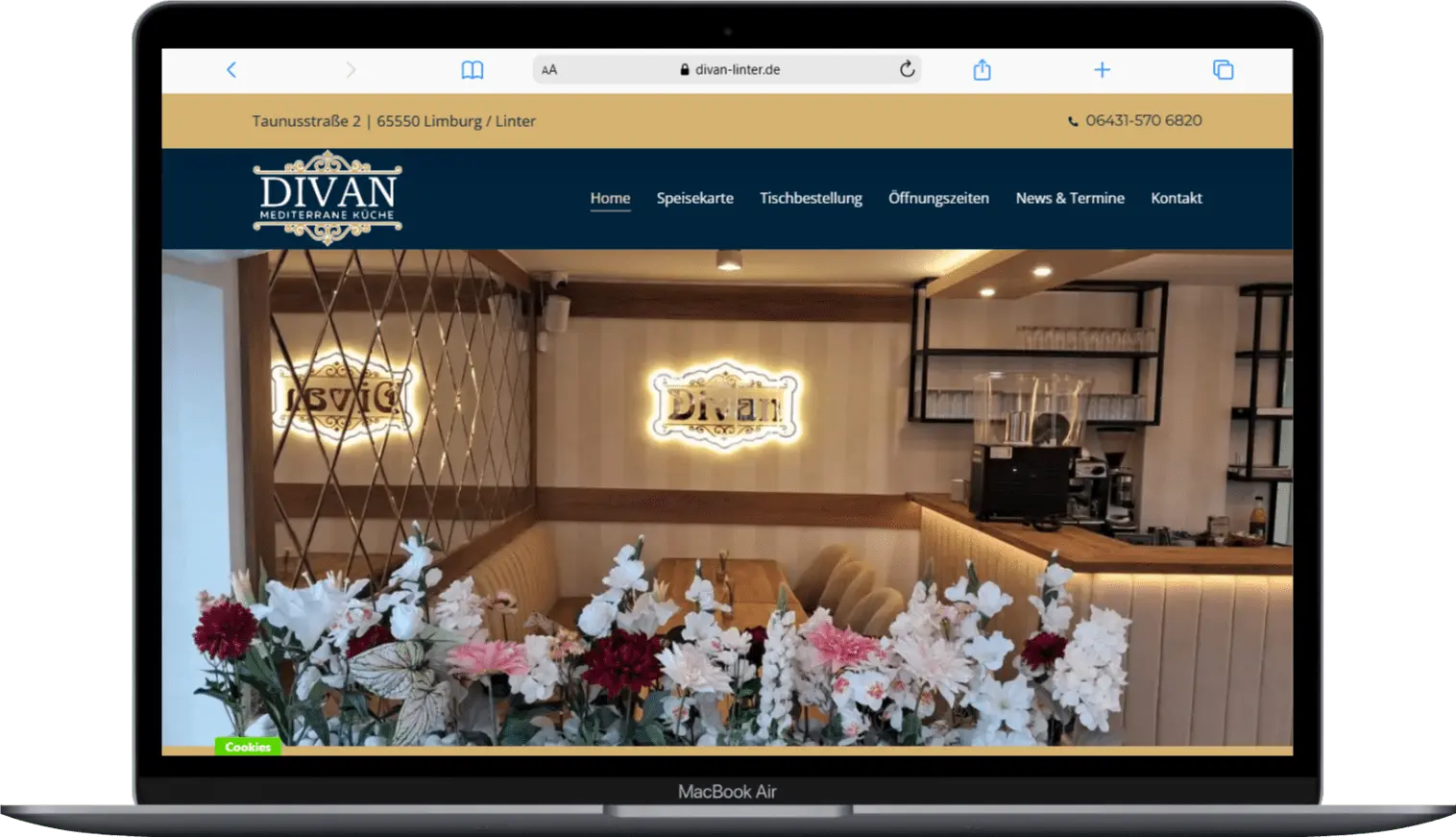 Interior view of Divan Mediterranean restaurant featuring floral decor and illuminated signage, creating a welcoming atmosphere.